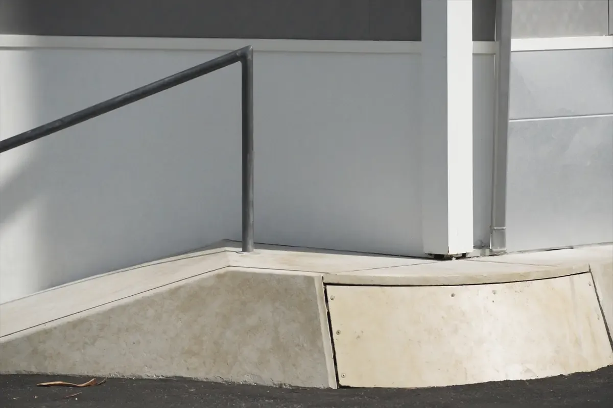 Concrete accessible ramp and handrail at the entrance of a commercial building in San Antonio, Texas