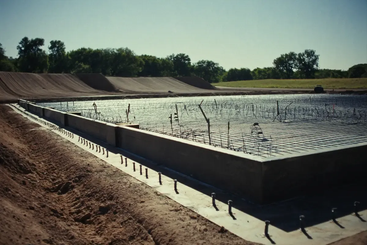 Concrete slab formed with rebar and anchor bolts set before the pour at a building site in South Texas