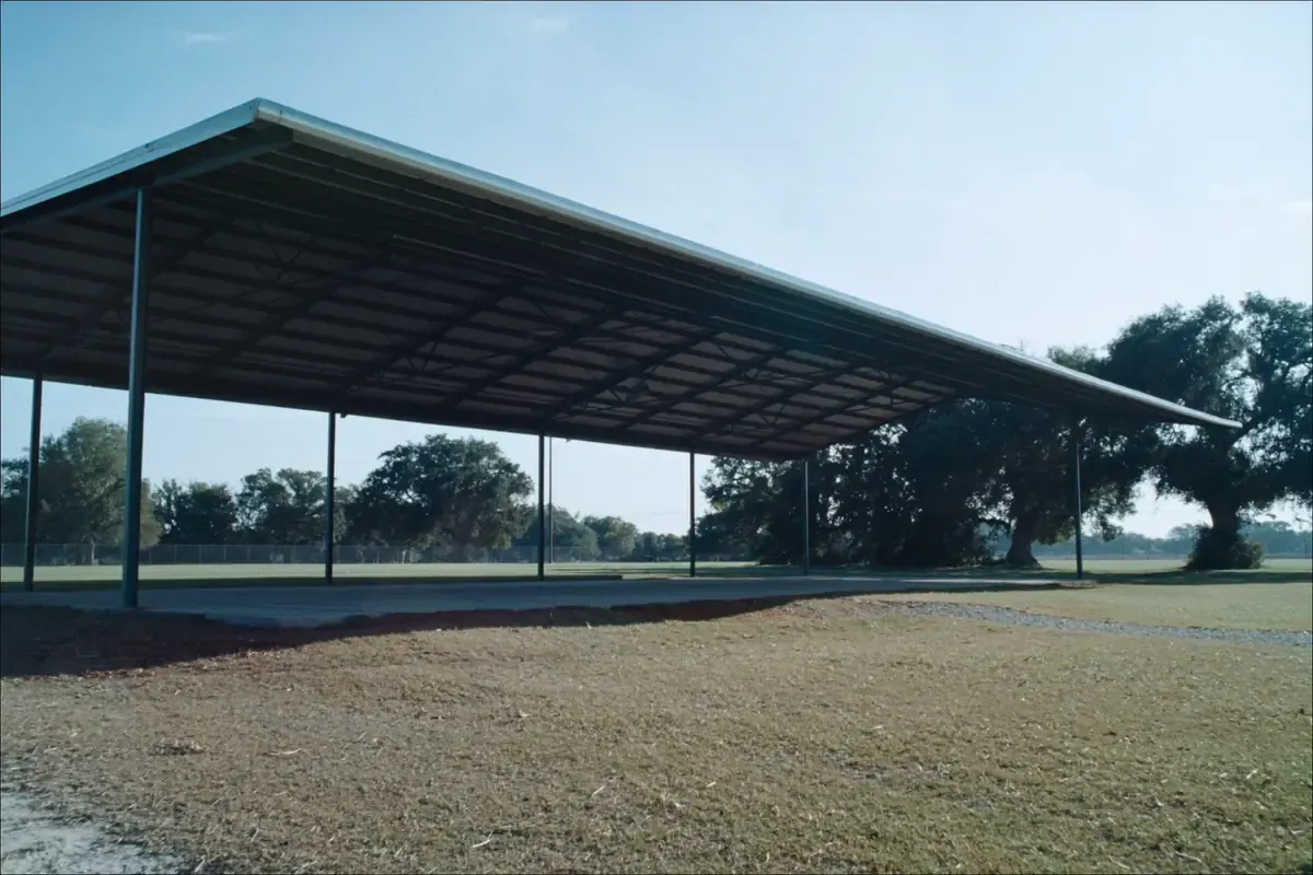 Steel canopy covering an open concrete court beside trees in the San Antonio area, Texas