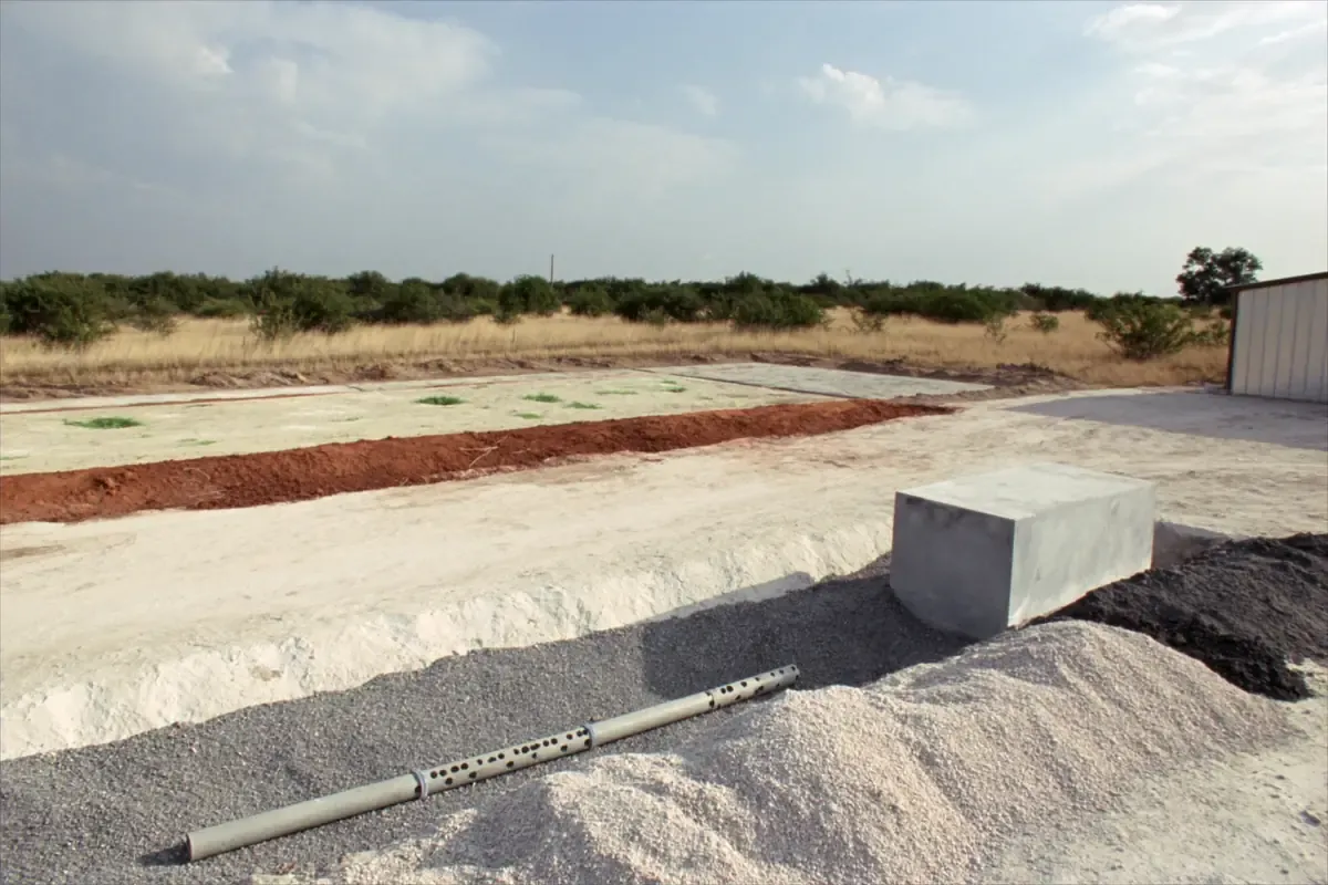 Septic tank and drainfield trenches with perforated pipe open on a caliche lot in South Texas